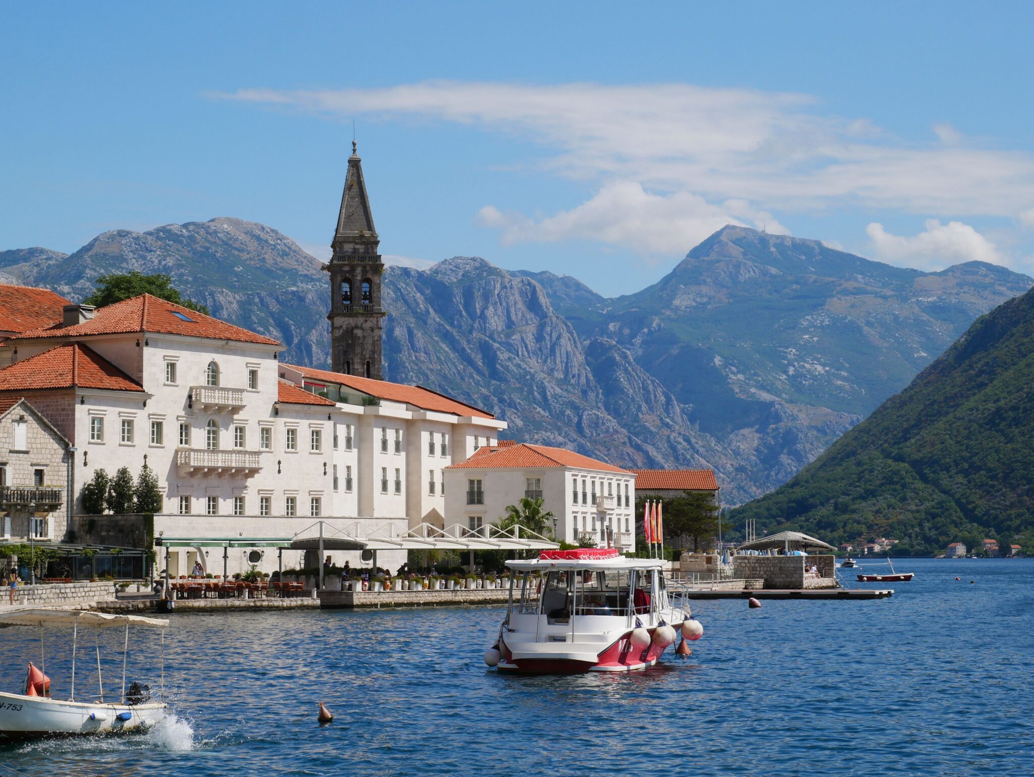 Explore the picturesque town of Perast with its stunning mountain backdrop and vibrant waterfront.